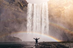 man, waterfall and rainbow
