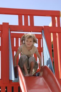 girl in playground on slide